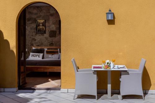 比拉克尔慕Somnis de l´Empordà的一张桌子和椅子坐在黄色的墙上