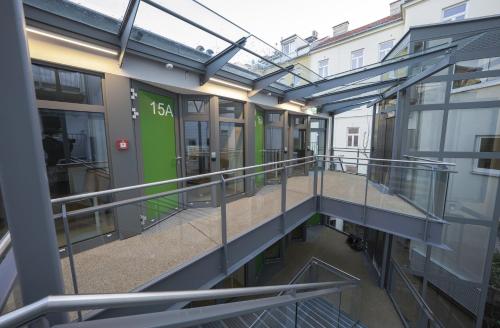 维也纳Smart Nano Living - Wien Hauptbahnhof的带有绿门的建筑的阳台