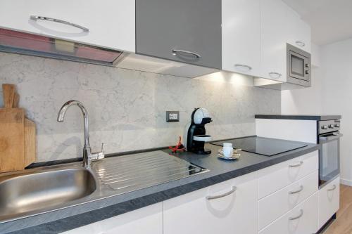 OriaFogazzaro Lake View Apartment的厨房配有白色橱柜和水槽