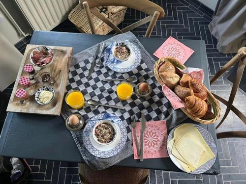 StolwijkB&B De Beijersche Stee , Logies in de Wagenschuur的餐桌,盘子上放着食物和面包篮