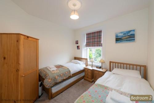 吉伦Hopetoun Cottage的一间卧室设有两张床和窗户。