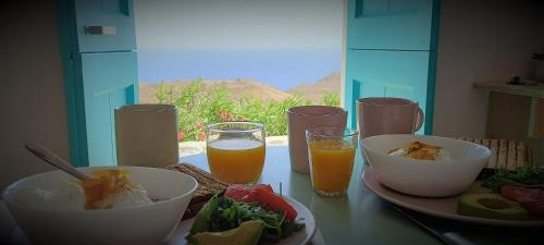 塞里福斯WabiSabi Serifos Chora w/ Spectacular Sea Views的餐桌,放着一碗食物和两杯橙汁