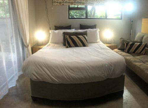 赫克托斯普雷特Gecko Cottages的一间卧室配有一张大床和一张沙发