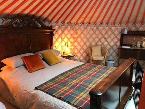 阿曼福德Gilfach Gower Farm Luxury Yurt with Hot Tub的一间位于橙色屋顶的客房的卧室,配有一张床