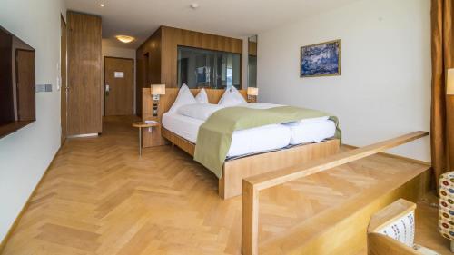 达沃斯Waldhotel & SPA Davos - for body & soul的一间卧室设有一张大床,铺有木地板