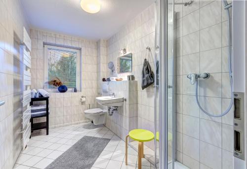 赛巴特班森Villa Madeleine KU 01的带淋浴、卫生间和凳子的浴室