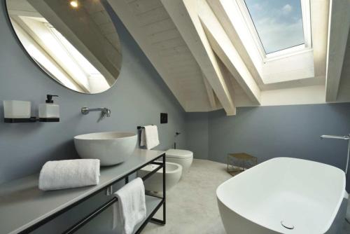 莱圭利亚Boutique Hotel de la Ville的浴室设有2个卫生间、水槽和天窗。