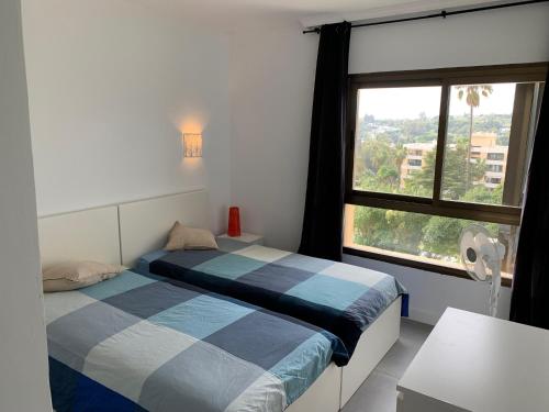 马贝拉Nice Flat close to Puerto Banus的一间卧室设有两张床和大窗户