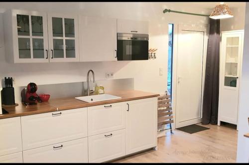 Port-MortLa Plage 2的厨房配有白色橱柜和水槽