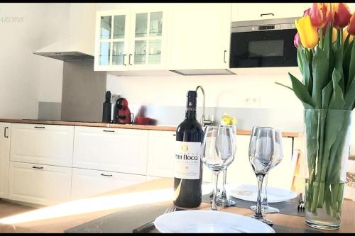 Port-MortLa Plage 2的厨房柜台上的一瓶葡萄酒和两杯酒杯