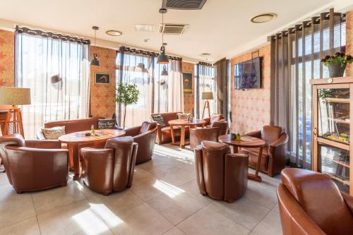 里加里加威尔顿SPA酒店的餐厅设有桌椅和窗户。