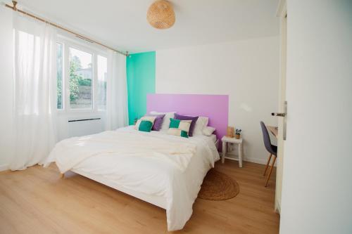瓦朗斯Casita - Comme une petite maison - Parking gratuit的一间卧室配有一张带色彩缤纷枕头的大床