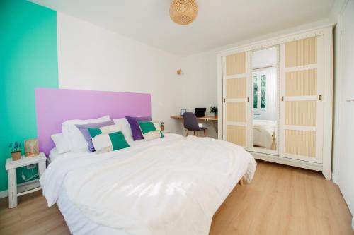 瓦朗斯Casita - Comme une petite maison - Parking gratuit的卧室配有一张白色大床和色彩缤纷的墙壁