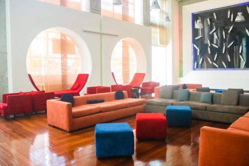 巴拿马城Decapolis Hotel Panama City的带沙发和红色及蓝色椅子的客厅