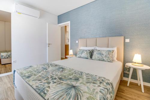 波瓦-迪瓦尔津Rua da Praia的一间卧室设有一张蓝色墙壁的大床