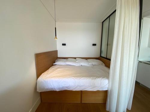 胡安莱潘CENTER BAY的卧室内的一张带白色床单和枕头的床
