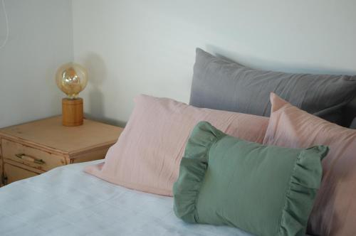 坦迪尔Hospedaje Sierra del Tigre II的一张带粉色和绿色枕头的床和一张桌子