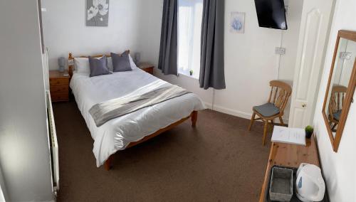 LincolnshireStepping Stones的一间卧室配有一张大床和镜子