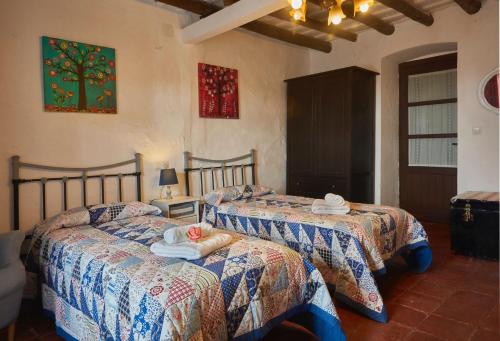 列雷纳Casa rural La Rosa de Llerena的一间卧室配有两张带毛巾的床