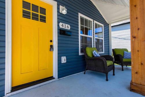 路易斯威尔Newly Renovated 3 Bedroom Shelby Park Home **FREE PARKING**的蓝色房子的黄色门,带椅子