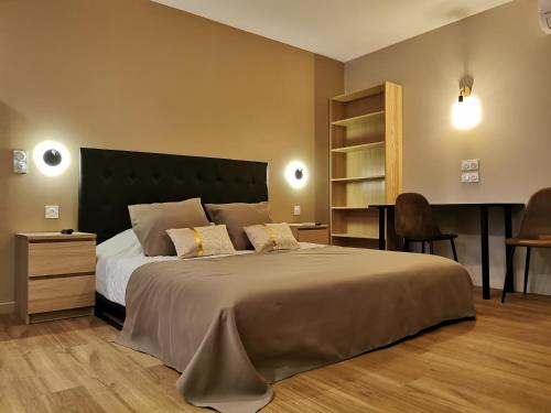 佩皮尼昂Appart Hotel Spa Perpignan的一间卧室配有一张大床和一张书桌