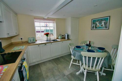 法拉姆灵厄姆Cottage in Framlingham的厨房配有桌椅和水槽。