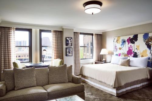 堪萨斯城拉斐尔酒店 - 堪萨斯城 的一间卧室配有一张床、一张沙发和窗户。