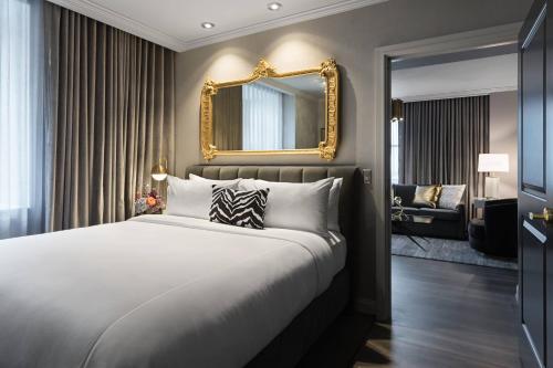 哥伦布勒维科傲途格精选酒店的一间卧室配有一张大床和镜子