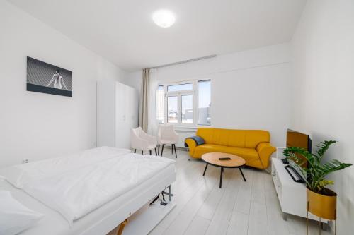 布拉迪斯拉发Self check-in apartments by Amber的白色的客房配有床和黄色的沙发