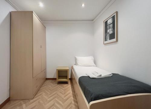 巴塞罗那Stay U-nique Apartments Calabria的一间带床和橱柜的小卧室
