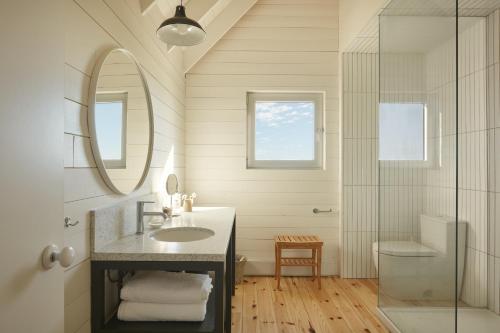 Havre-AubertLes Rochers - Îles de la Madeleine的一间带水槽、镜子和淋浴的浴室