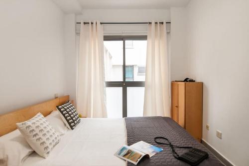 大加那利岛拉斯帕尔马斯Cosy flat in the beach的卧室配有白色的床和窗户