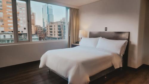 波哥大Faranda Express Belvedere的卧室设有一张白色大床和一扇窗户。