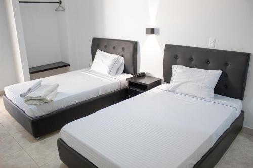库库塔Hotel Fenix的两张位于酒店客房的床,配有两张sidx sidx单人床