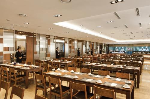 首尔美利来酒店首尔明洞.的一间大餐厅,配有桌子,后面有人