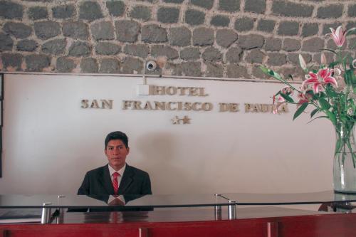 阿亚库乔Hotel San Francisco de Paula Ayacucho的坐在桌子上的男人穿着西装,领带
