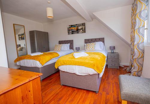 凯特林Saviour Manor的一间卧室配有两张带黄色毯子的床