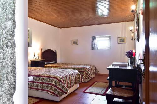 FontouraCasa da Quinta do Cruzeiro的酒店客房配有两张床和一张书桌