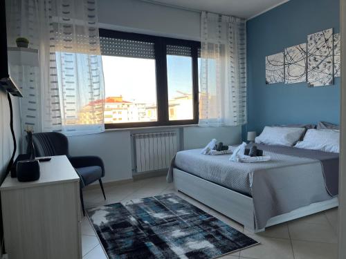 佩斯卡拉Casa Manthone - Intero Appartamento的蓝色卧室,配有床和椅子