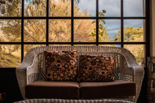 塔里哈Casa de Campo La Montaña的大窗户前的带枕头的藤椅