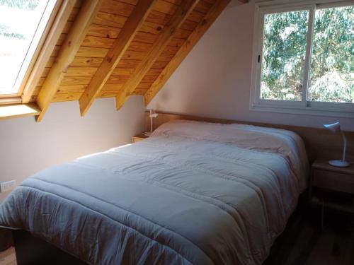 塞拉德洛斯帕德雷斯Cielo de sierra的卧室内的一张床铺,设有大窗户