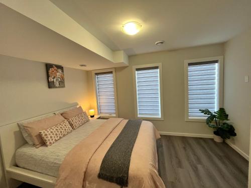 温尼伯Cozy Private 1 bedroom basement suite - free parking and free Wifi的一间卧室设有一张床和三个窗户。