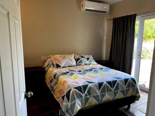 艾尔贝迪托FREE CAR W/ Private House & Ocean View的一间卧室配有一张带五颜六色棉被的床