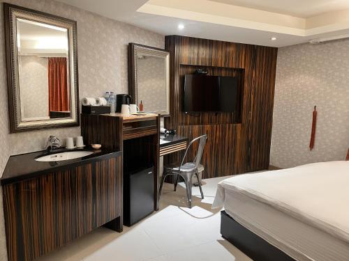 台北承携行旅-台北信义馆(豪丽旺)的酒店客房配有床、书桌和水槽