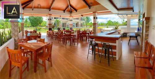 锡基霍尔La Candura的一间带木桌椅的餐厅和一间酒吧