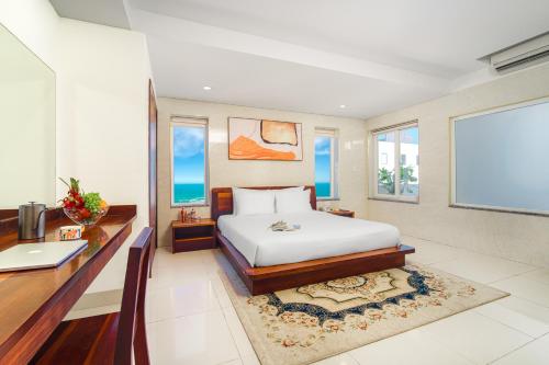 岘港SOCO Hotel by THG的一间卧室配有一张床、一张书桌和一些窗户。