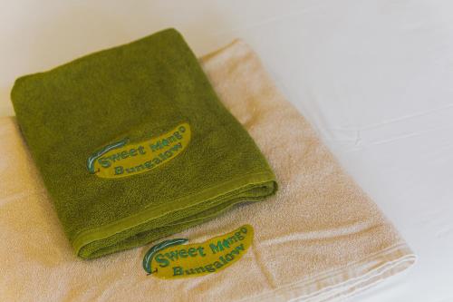 蔻立Sweet Mango Khaolak的毛巾上方的两条绿色毛巾