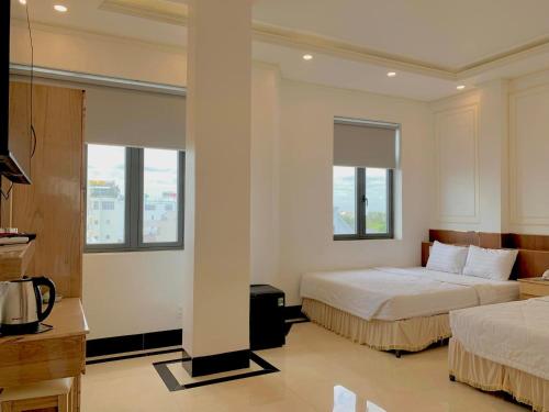 Bạc LiêuPhụng Hoàng Vũ的酒店客房带两张床和两个窗户