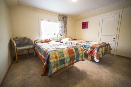 罗瓦涅米坎皮度假屋阿克努斯酒店的一间卧室设有两张床、一把椅子和一个窗户。