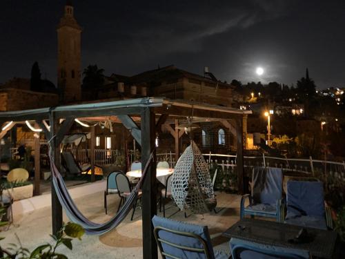 耶路撒冷Sweet ‘En Kerem View的一个带椅子的游乐场和夜间秋千